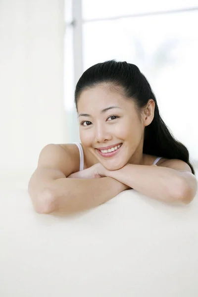 Mulher Sentada Sofá Sorrindo Para Câmera — Fotografia de Stock