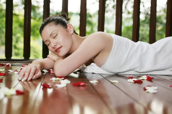 Mujer Acostada Sobre Plataforma Madera Con Pétalos Flores Dispersos —  Fotos de Stock