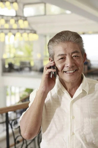 Άνθρωπος Χαμογελά Ενώ Μιλάει Στο Κινητό Τηλέφωνο — Φωτογραφία Αρχείου