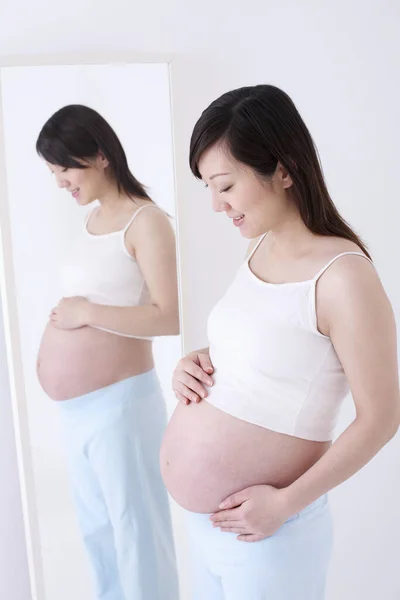 Беременная Женщина Смотрит Свой Живот — стоковое фото