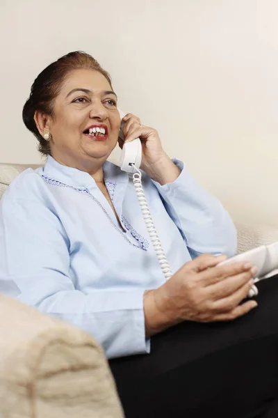 Μια Ηλικιωμένη Γυναίκα Μιλάει Στο Τηλέφωνο Χαμογελώντας — Φωτογραφία Αρχείου