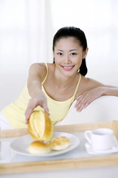 Kadın Elinde Çörek Tutarken Gülümsüyor — Stok fotoğraf
