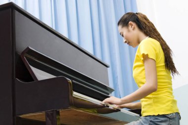 Piyano çalan genç bir kadın