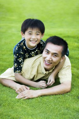 Baba oğul parkta poz veriyor.