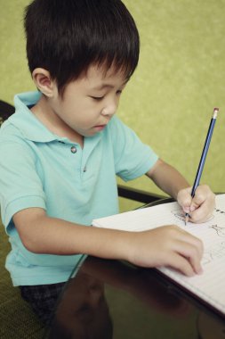 Çocuk ödevini yapıyor.