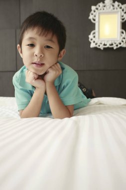 Yatakta ileri doğru uzanan çocuk