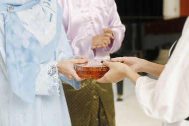 Bir kadın, Hari Raya sırasında arkadaşına bir kutu geleneksel kurabiye veriyor.