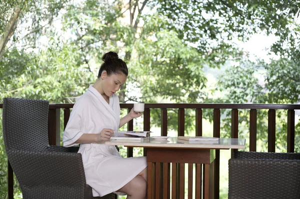 Mujer Volteando Libro Mientras Sostiene Una Taza —  Fotos de Stock