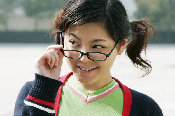 Girl Smiling While Adjusting Her Spectacles — Stock Photo, Image