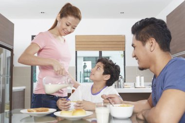 Anne oğlunun kasesine süt döktü.