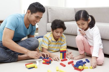 Neşeli baba çocuklarıyla oynuyor.