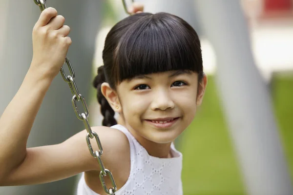 女の子はスイングに座って — ストック写真