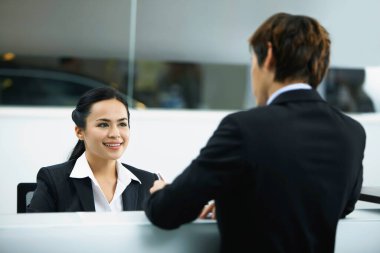 Satış temsilcisi tezgahtaki bir müşteriyle iletişim kuruyor