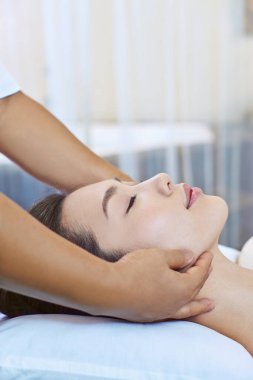 Genç bir kadın kafa masajı yaptırıyor.