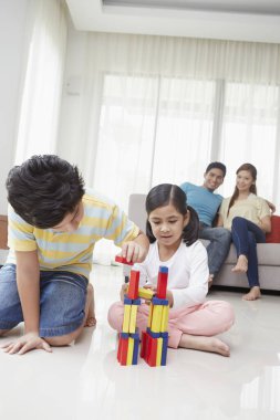 Oğlan ve kız bloklarla oynuyorlar.