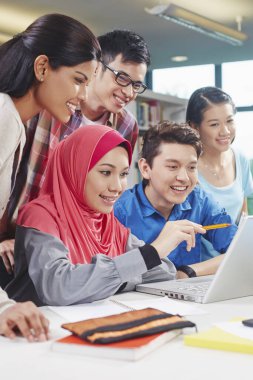 Öğrenciler kütüphanede birlikte okuyorlar