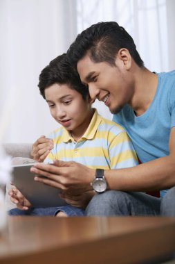 Baba ve oğul birlikte dijital tablet kullanıyorlar.