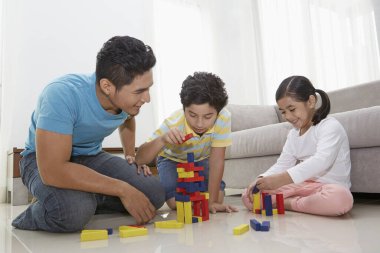 Neşeli baba çocuklarıyla oynuyor.