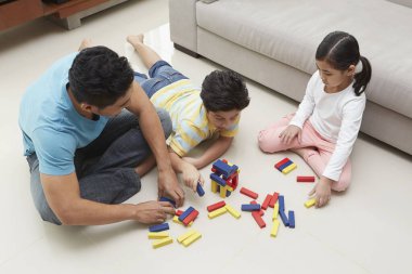 Neşeli baba çocuklarıyla oynuyor.