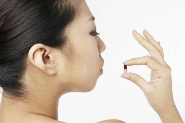 Kapsül tutan kadının yakın çekimi.