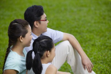 Sahada ailesiyle oturan bir kız.