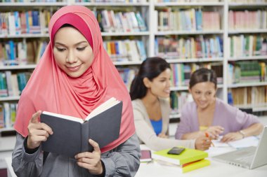 Öğrenciler kütüphanede birlikte okuyorlar