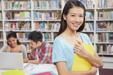 Kütüphanedeki öğrenciler / kameraya gülümseyen kadın