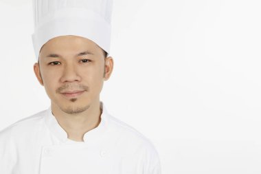 Asyalı şef kameraya bakıyor.