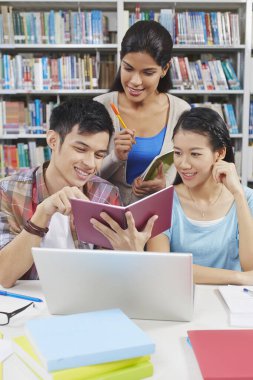 Öğrenciler kütüphanede birlikte okuyorlar