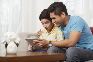 Baba ve oğul birlikte dijital tablet kullanıyorlar.