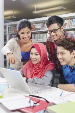 Öğrenciler kütüphanede birlikte okuyorlar