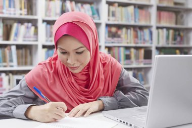 Kütüphanede okuyan bir öğrenci.