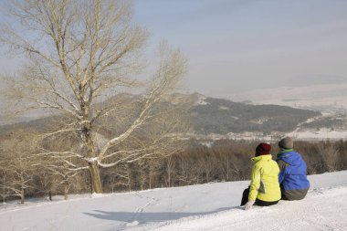 Erkek ve kadın kış günü manzaranın tadını çıkarıyorlar.