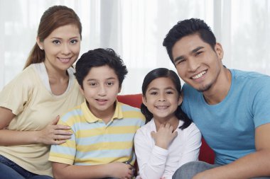 Dört kişilik aile kameraya gülümsüyor.