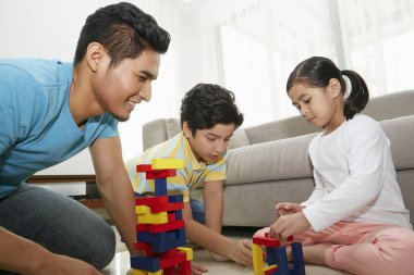 Neşeli baba çocuklarıyla oynuyor.