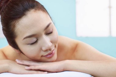 Genç bir kadın uzanmış, dinleniyor.