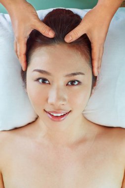 Genç bir kadın kafa masajı yaptırıyor.