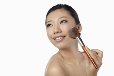 Yüzüne allık süren bir kadın.