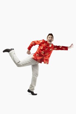 Geleneksel giysili bir adam koşuyor ve uzanıyor.