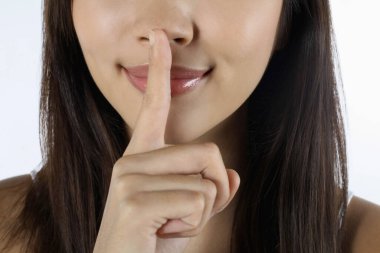 Dudaklarında parmak olan bir kadın.