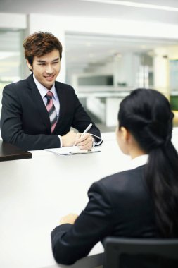 Satış temsilcisi tezgahtaki bir müşteriyle iletişim kuruyor