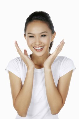 Elleri çenesinin altında açık gülümseyen mutlu kadın.