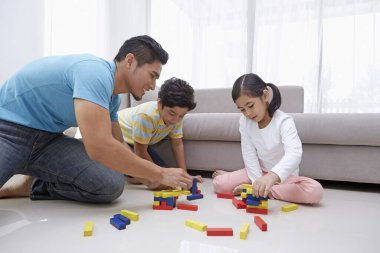 Neşeli baba çocuklarıyla oynuyor.