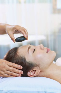 Bir masöz kadının alnına taş koydu.