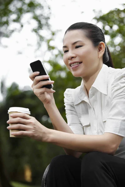 中高年ビジネス女性スマートフォン上のテキストメッセージ — ストック写真