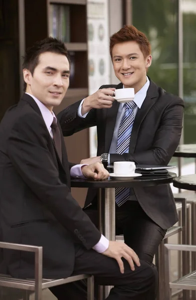 Businessmen having coffee at outdoor cafe