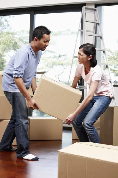 Man and woman lifting cardboard box together