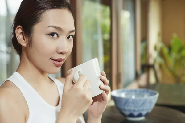 A young woman holding a mug