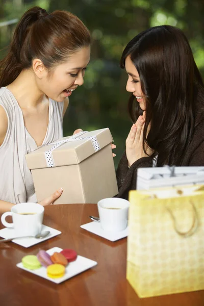 Woman presenting gift to friend