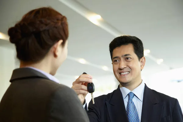 Sales Representative Handing Keys Customer Car Showroom — Stock Photo, Image